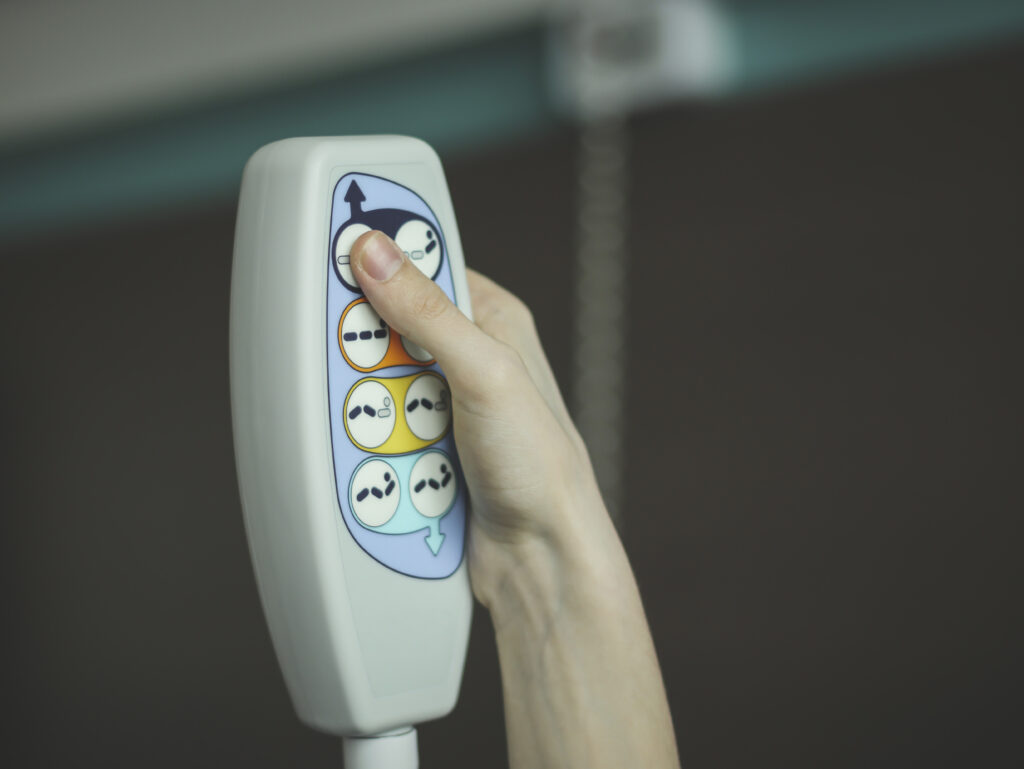Hand of a young white person pushing the button on a nursing call system
